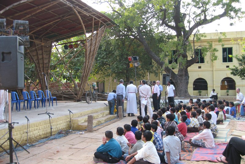 Audience gathered waiting to watch performance on bamboo stage