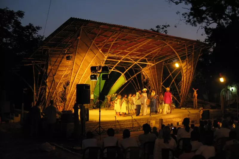 Bamboo constructed stage at night lit up with children performing