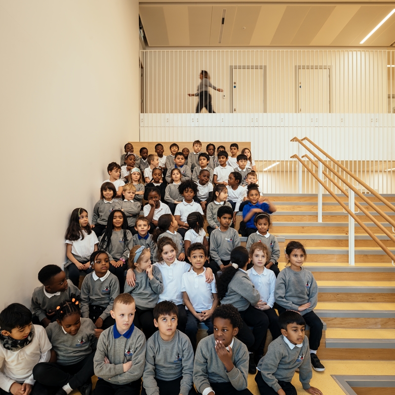 Royal Wharf Primary School children sat on stairs
