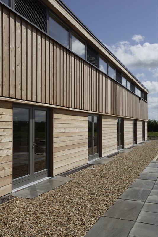 Facade composition with untreated Lark cladding & timber framed glazing